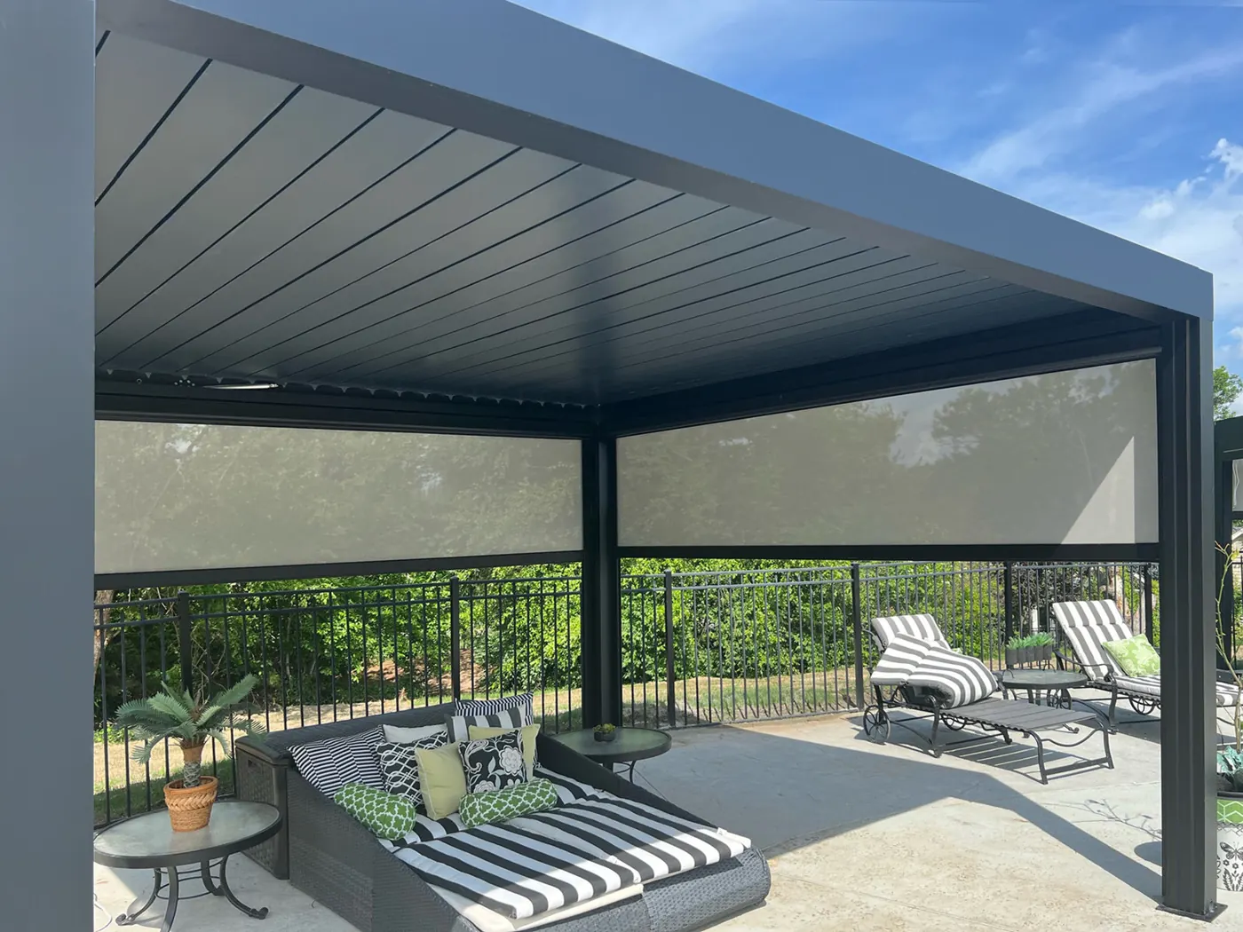 Pergola bioclimatique avec stores screen, transats au bord de la piscine