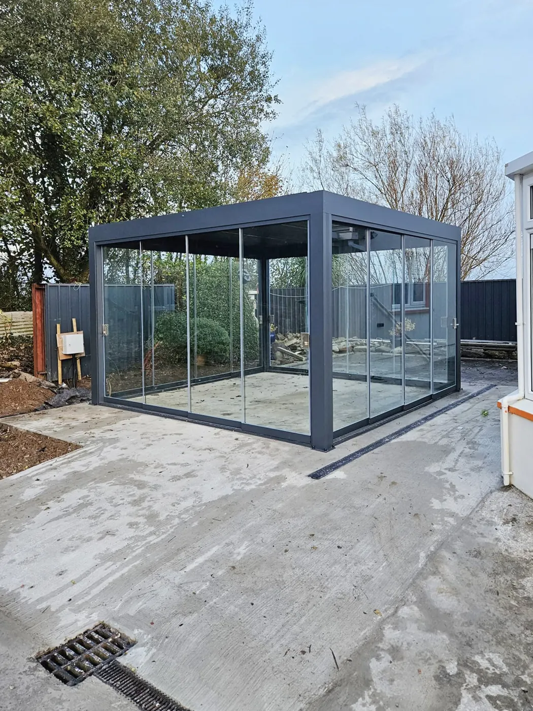 Pergola bioclimatique vitrée sur une terrasse neuve