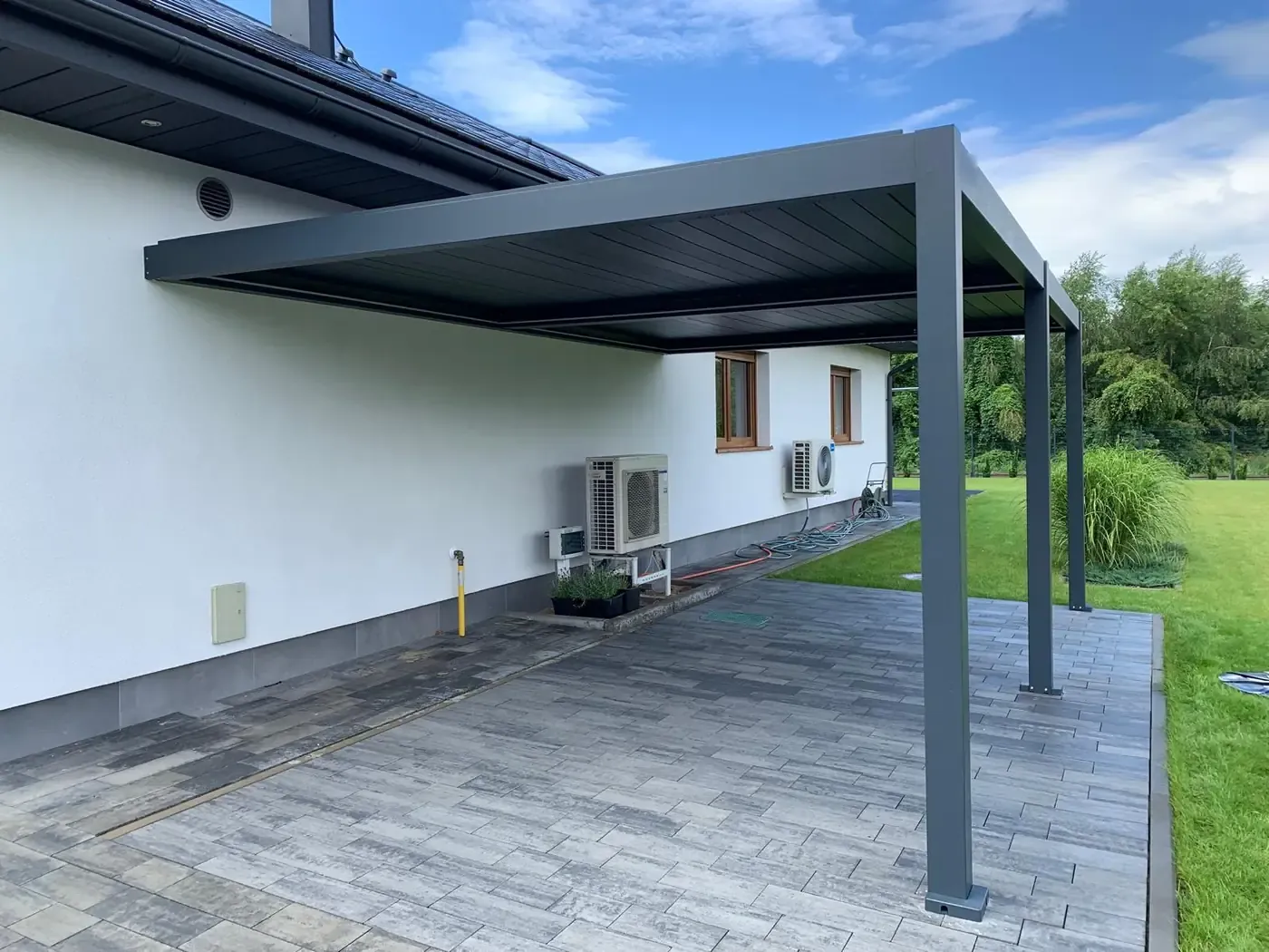 Pergola bioclimatique adossée à une maison, lames fermées