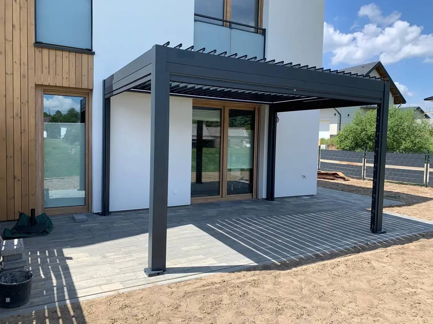 Pergola bioclimatique adossée, lames ouvertes au soleil
