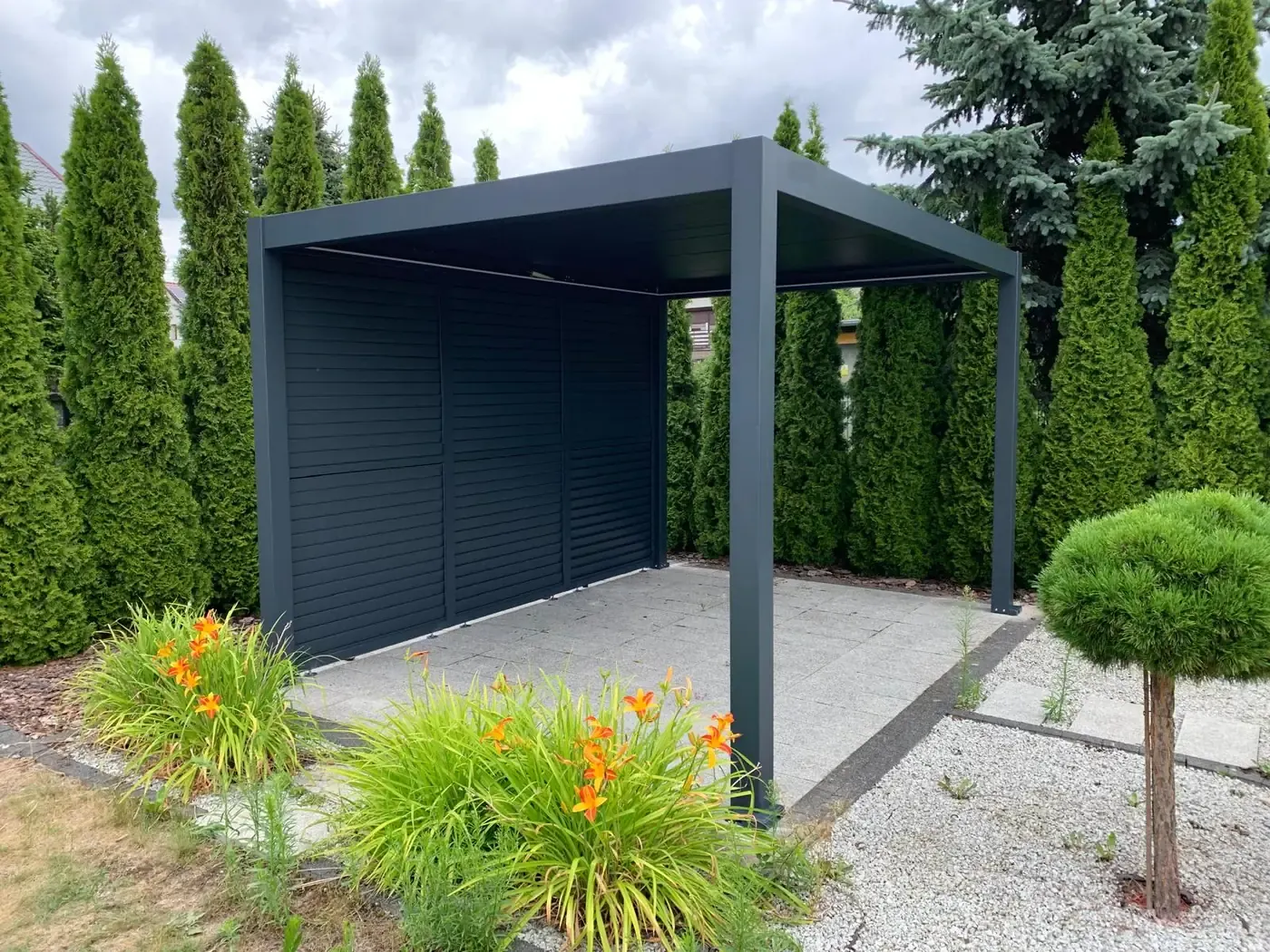 Pergola bioclimatique avec persienne, entourée de thuyas