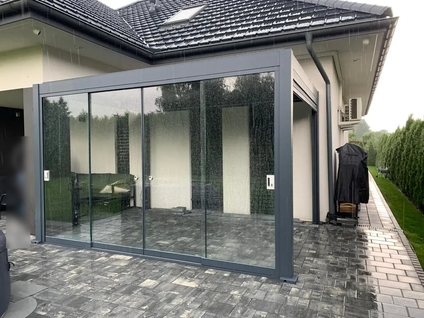 Pergola bioclimatique vitrée sous la pluie
