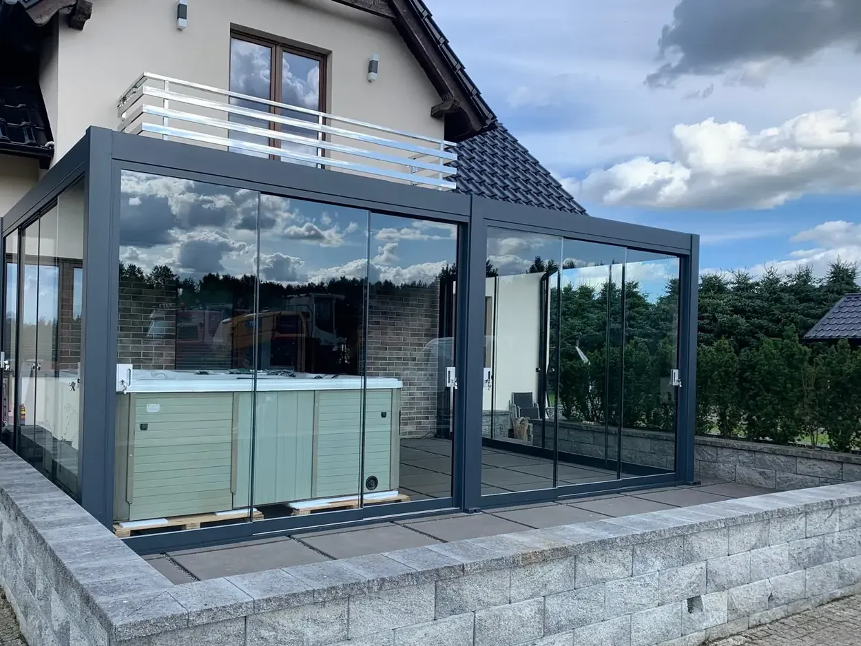 Pergola bioclimatique vitrée abritant un spa
